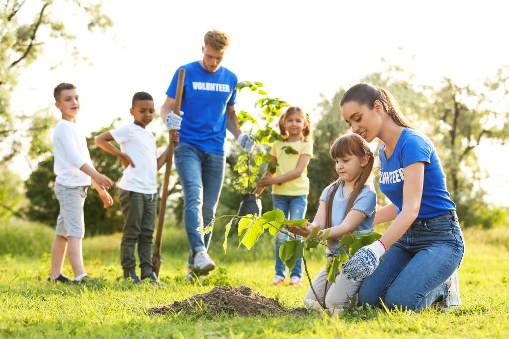 Kids planting trees with volunteers in park Alliance 2020